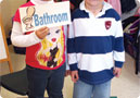 Children holding bathroom sign