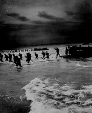 American troops leap forward to storm a North African beach during amphibious maneuvers in 1944. (National Archives)